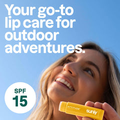 ATTITUDE lip balm beside a hand for size and pocket-friendly scale