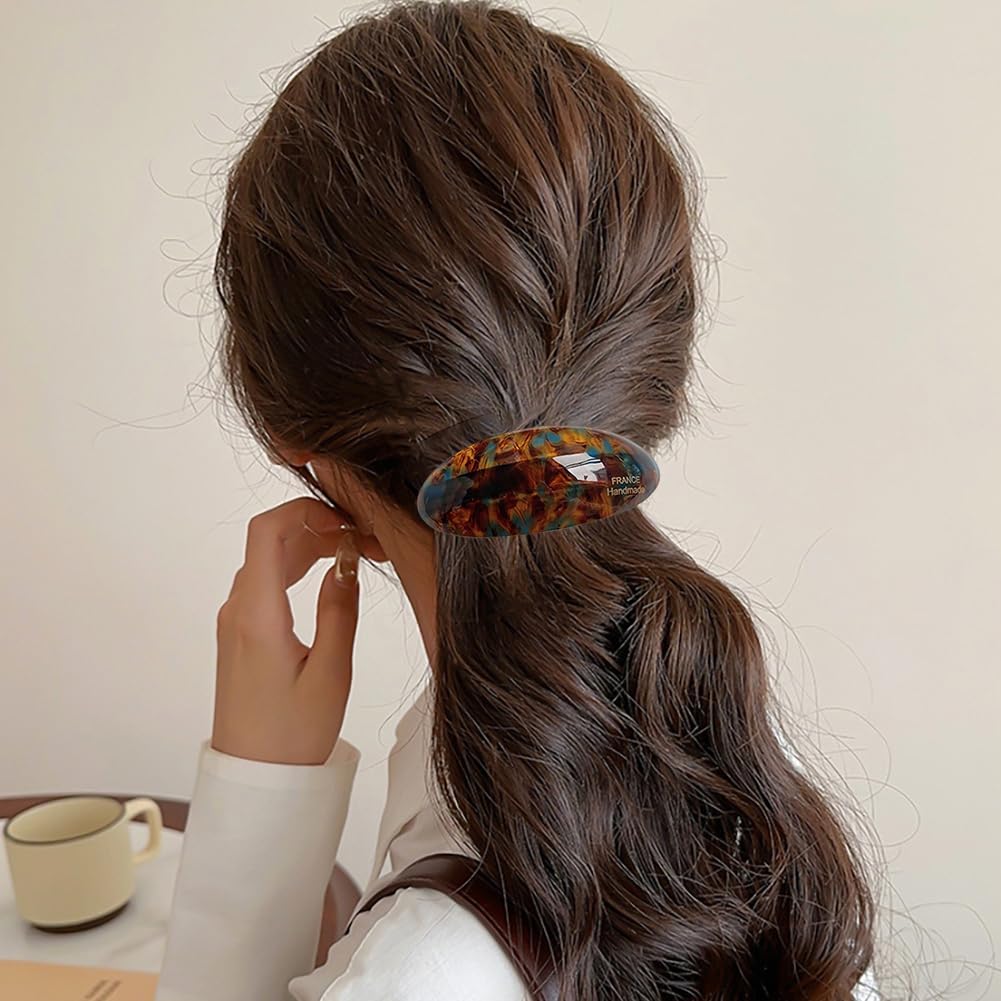 Auswalar barrette in hand to show size and scale for easy styling and travel-friendly convenience