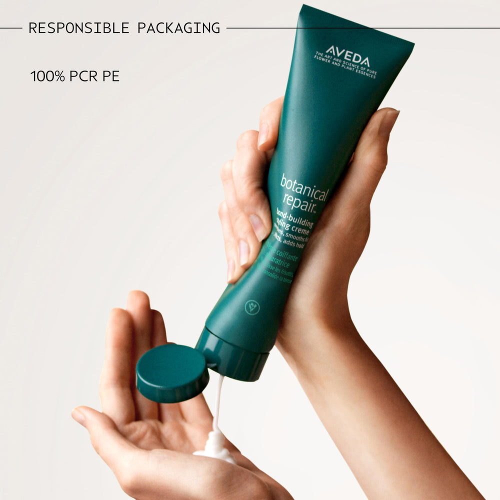 Stylist applying Aveda creme during blow-dry for frizz control and styling