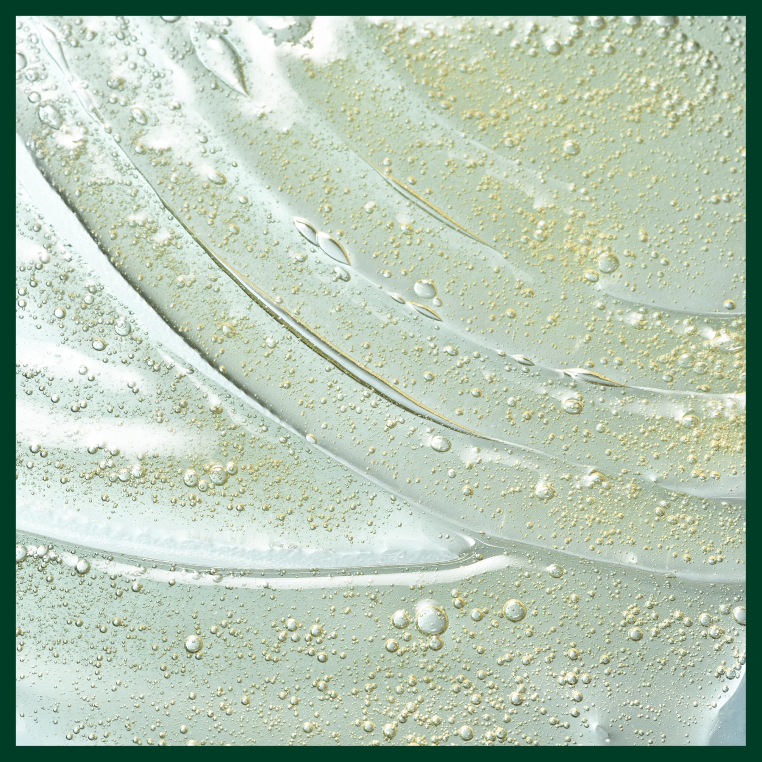 Aveda product next to plant extracts to emphasize mostly naturally derived ingredients