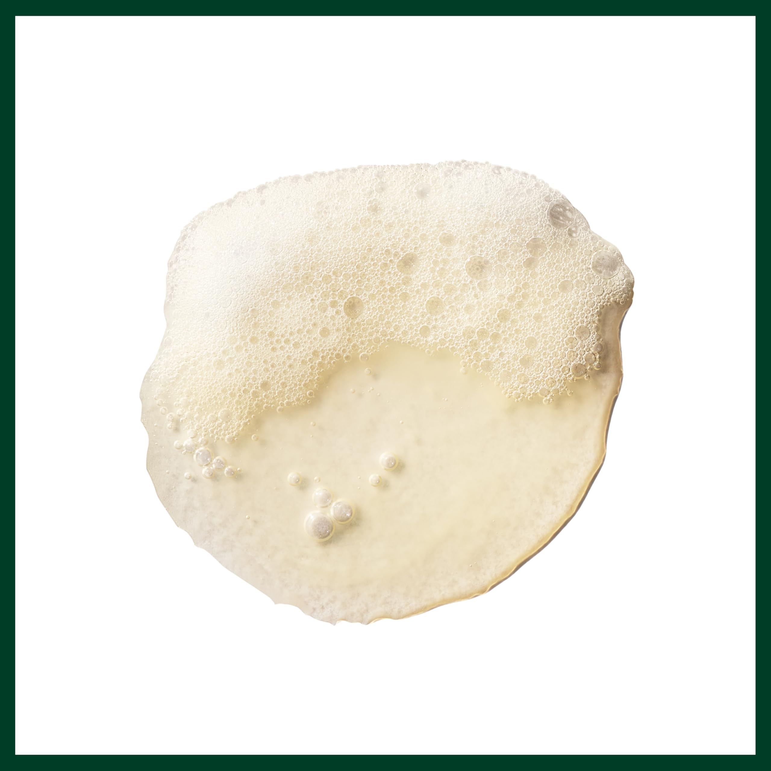 Aveda bottle beside coconut and sunflower, emphasizing natural ingredients benefit