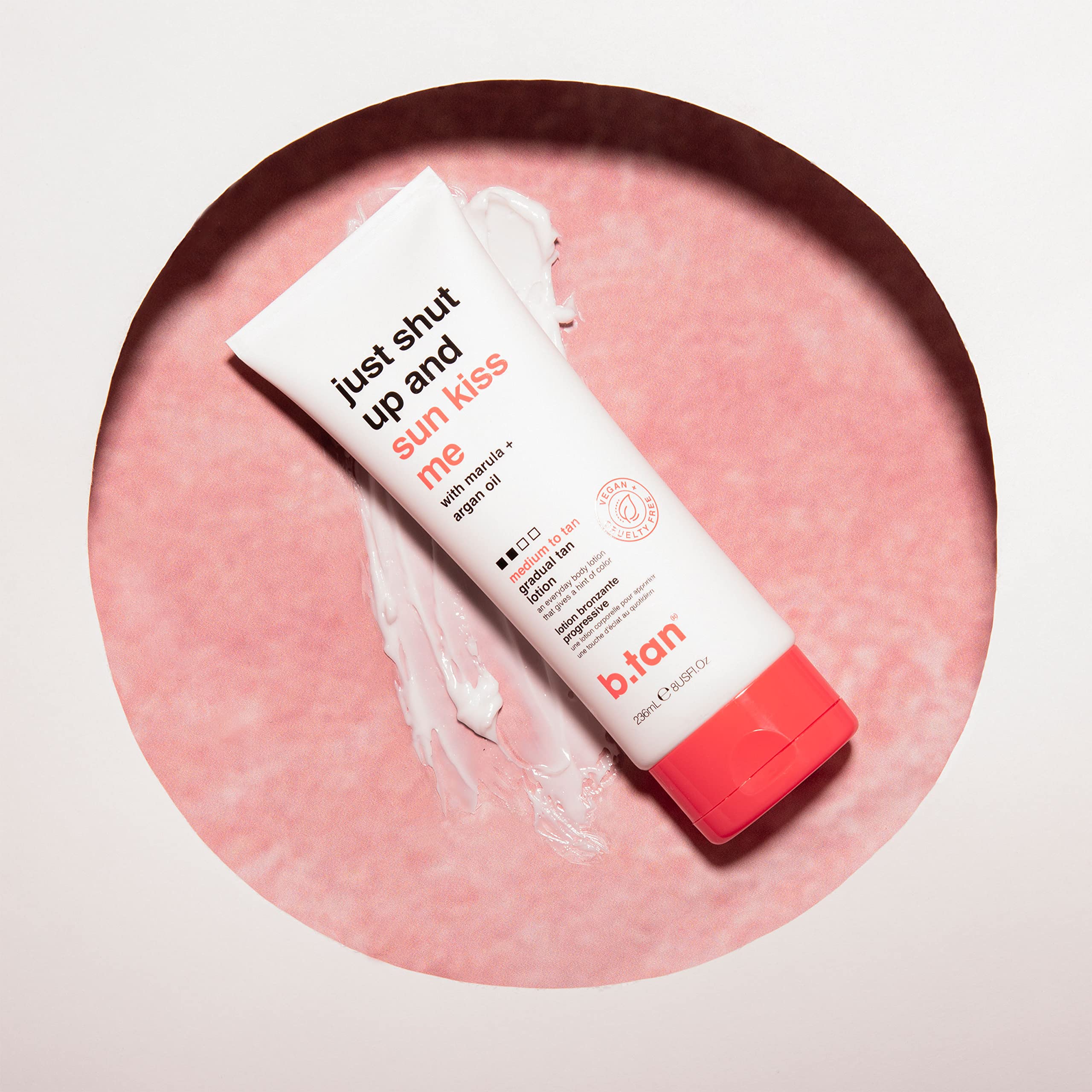 b.tan bottle beside towels in bathroom suggests daily skincare routine