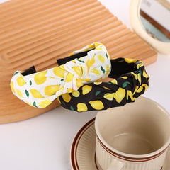 BaBakiak headbands laid beside ruler showing approximate two-inch width