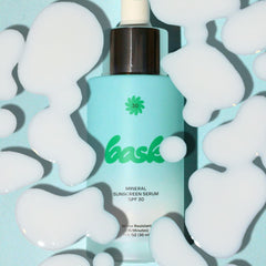 Bask 1 oz bottle next to coin showing compact travel size