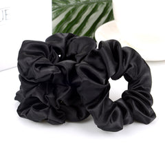 BBTO scrunchie beside a coin to show compact size and fit