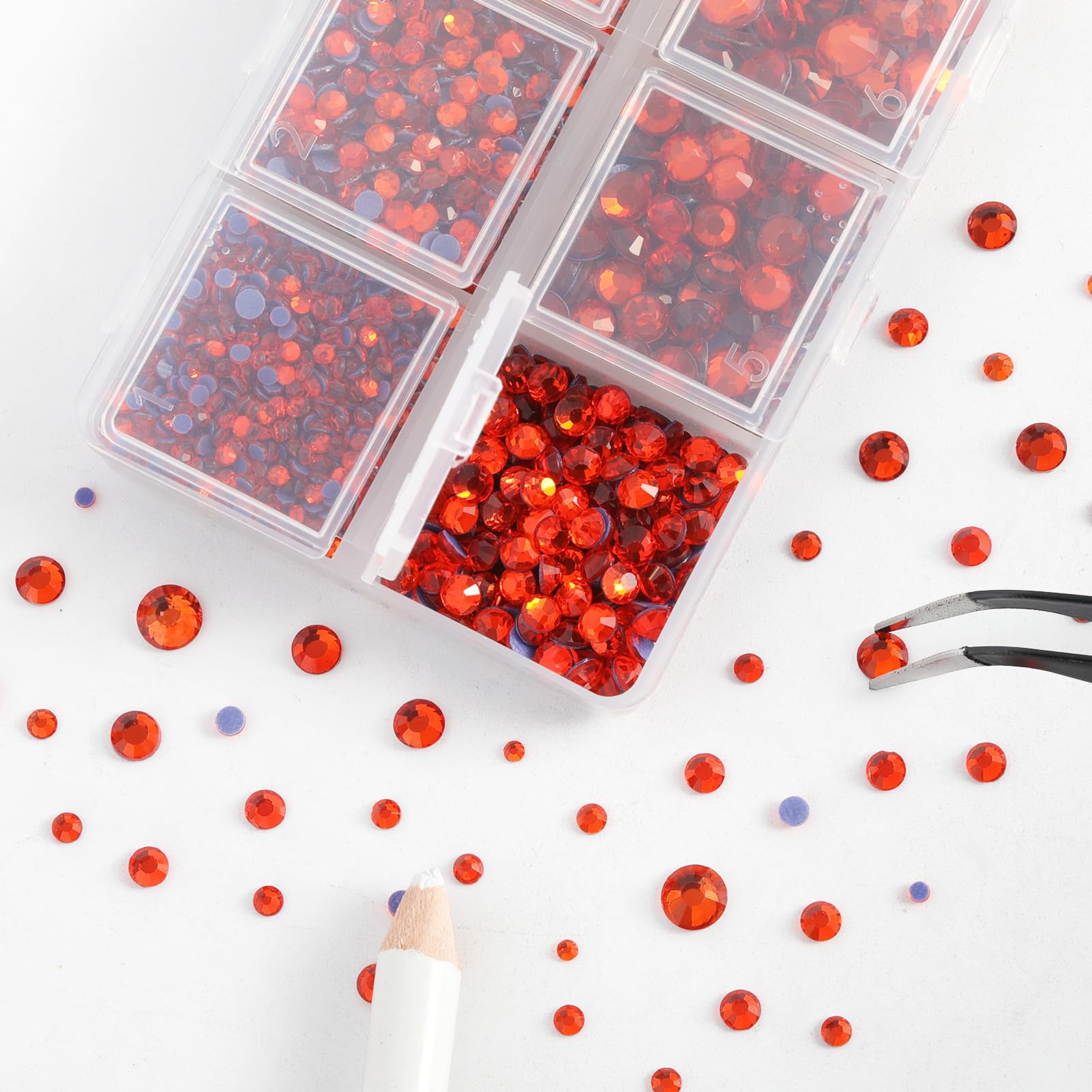 BEADSLAND tweezers and wax pencil picking a rhinestone for precise placement benefit