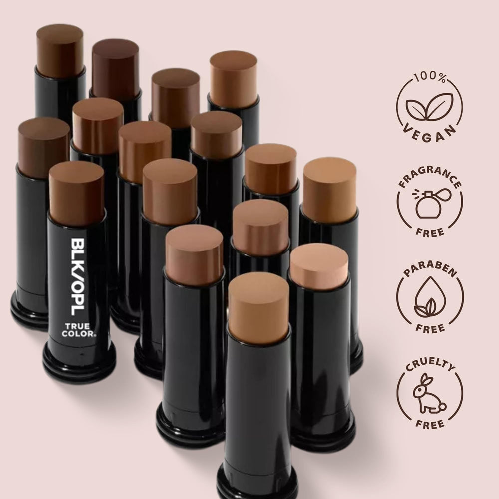 Black Opal foundation stick held between fingers showing compact travel size