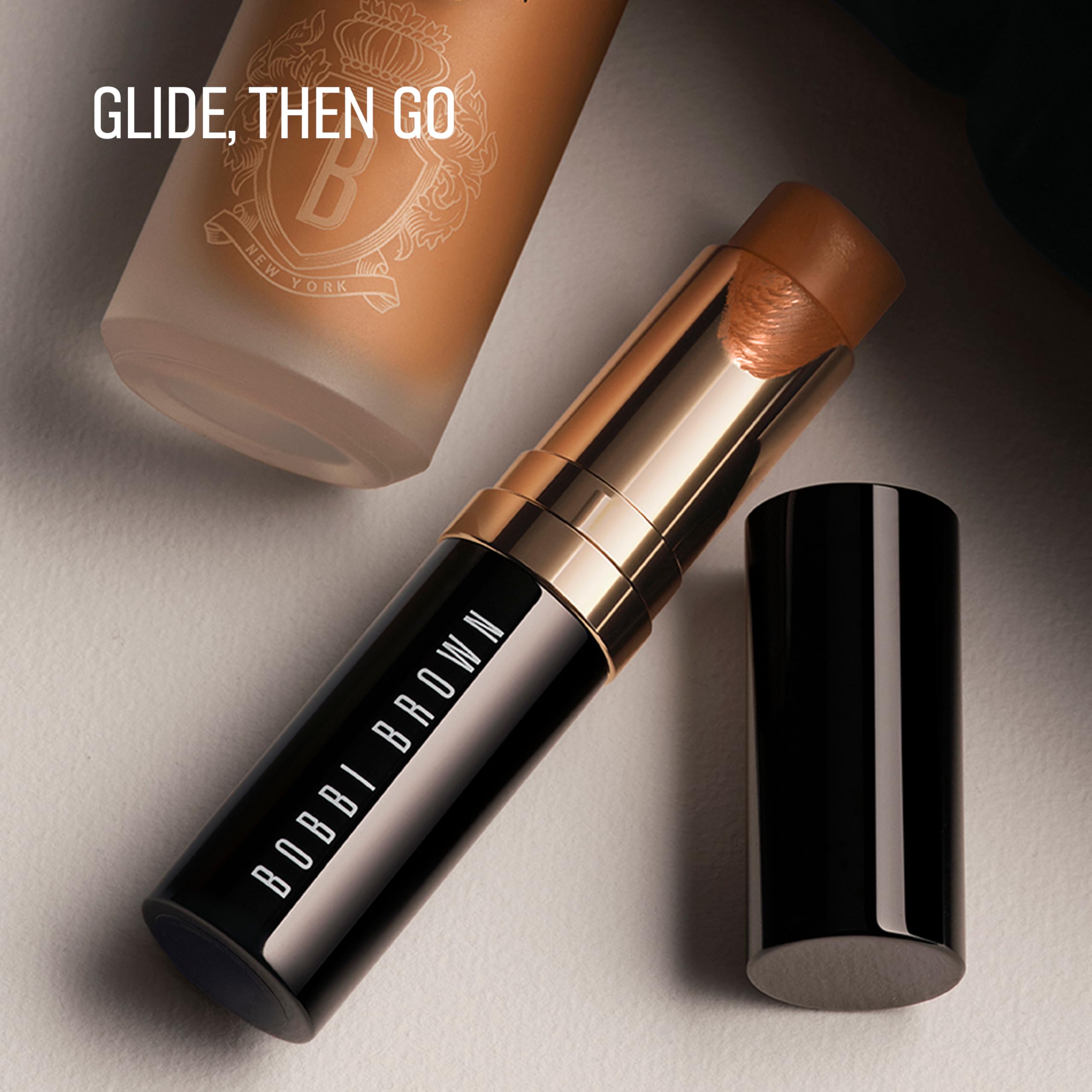 Bobbi Brown foundation stick next to hand and mirror for scale and travel convenience