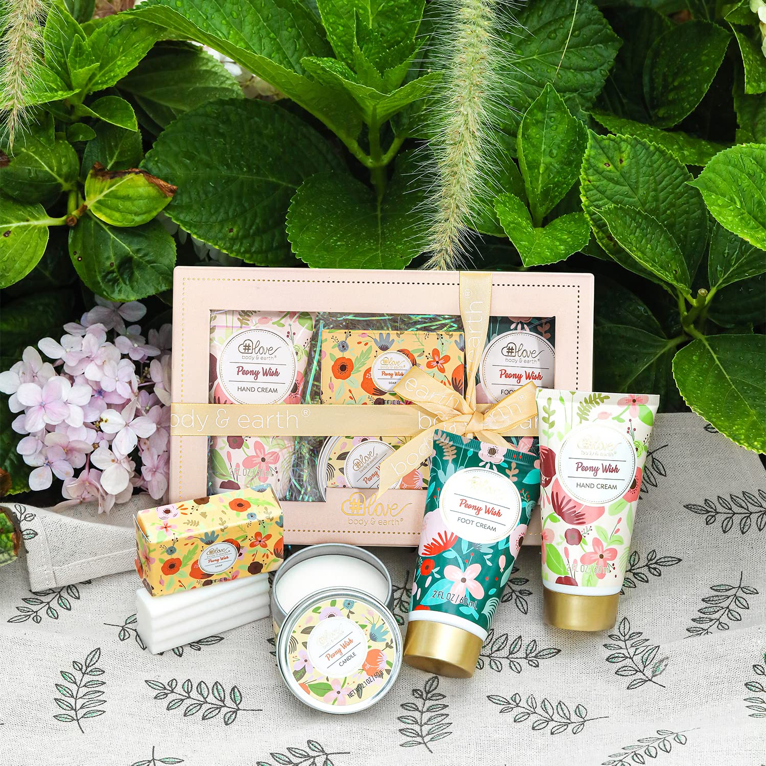 BODY & EARTH # LOVE hand holding products for scale illustrating travel-friendly sizes