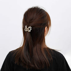 Brinie clips next to hand illustrating medium and small sizes for scale