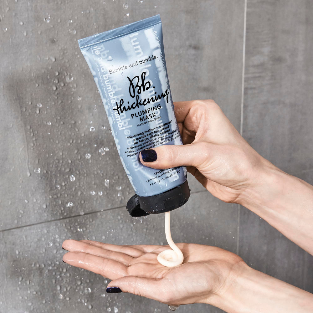 Bumble and bumble size comparison bottle next to hand for travel-friendly benefit