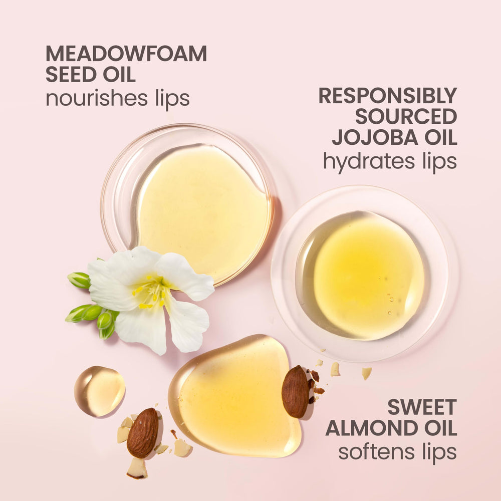 Burt's Bees lip oil beside coins to show compact travel-friendly size