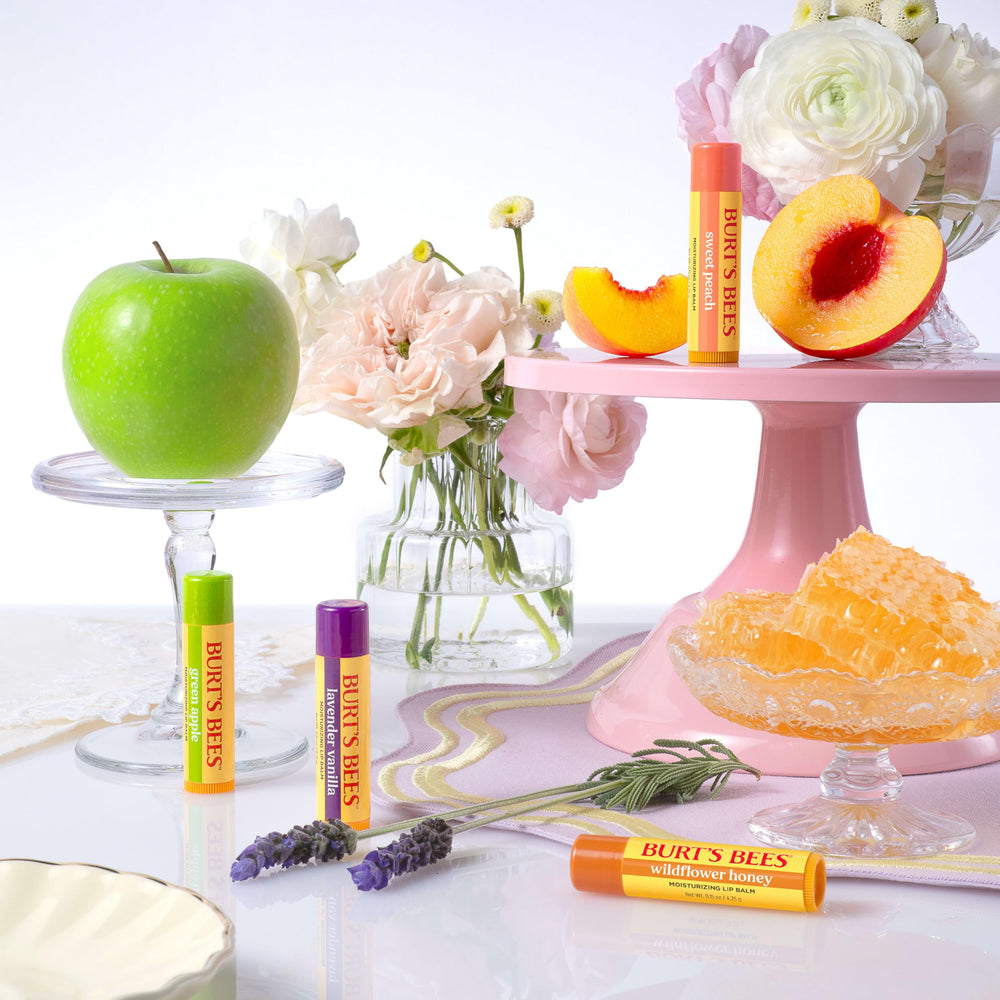 Burt's Bees size comparison with coin showing compact, travel-friendly tubes