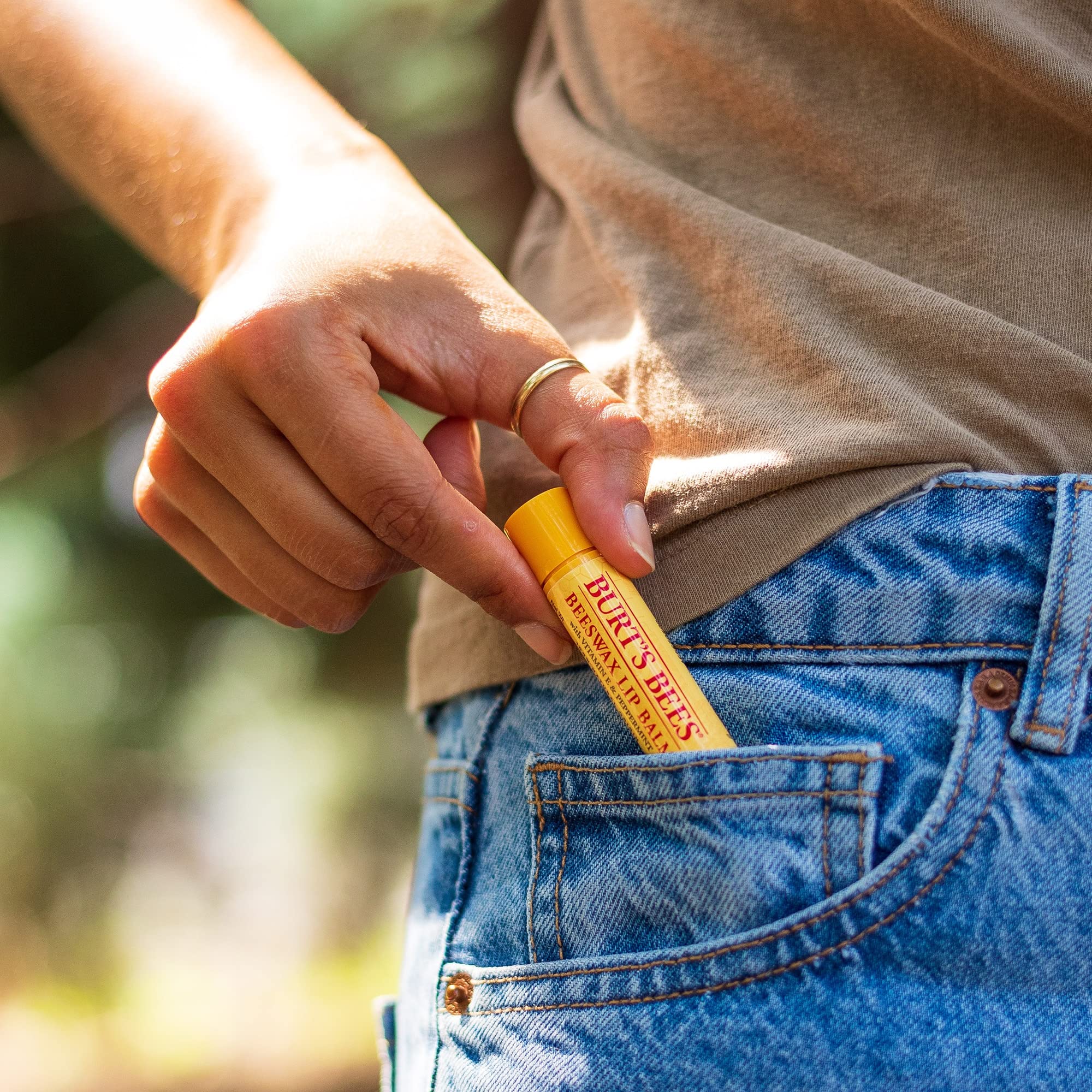 Burt's Bees tube next to a coin for size comparison and portability benefit