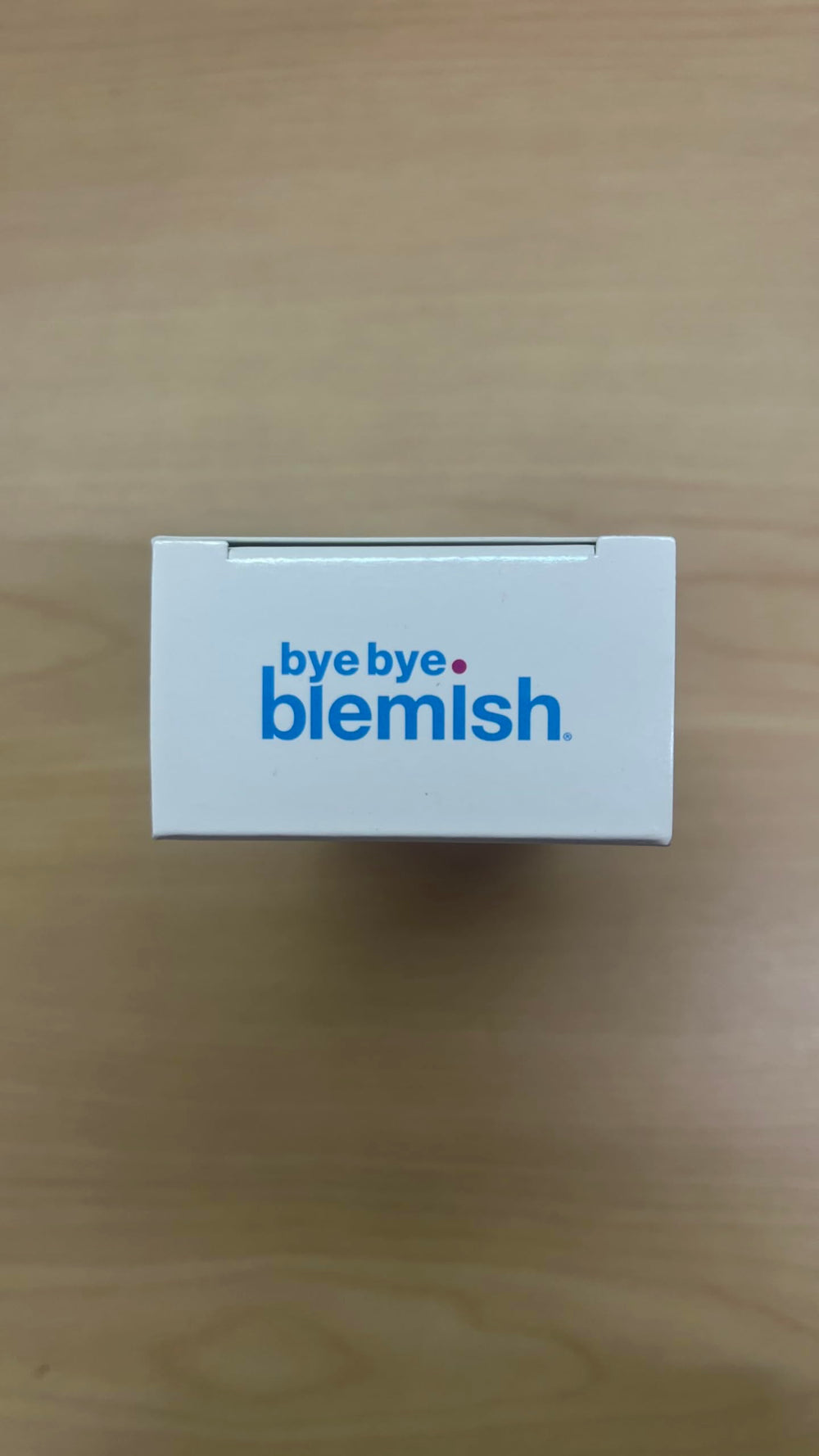 Bye Bye Blemish on a nightstand beside pillow to show evening routine placement and ease-of-use benefit