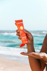 Calypso in a beach bag lifestyle shot conveying sun-ready hair care