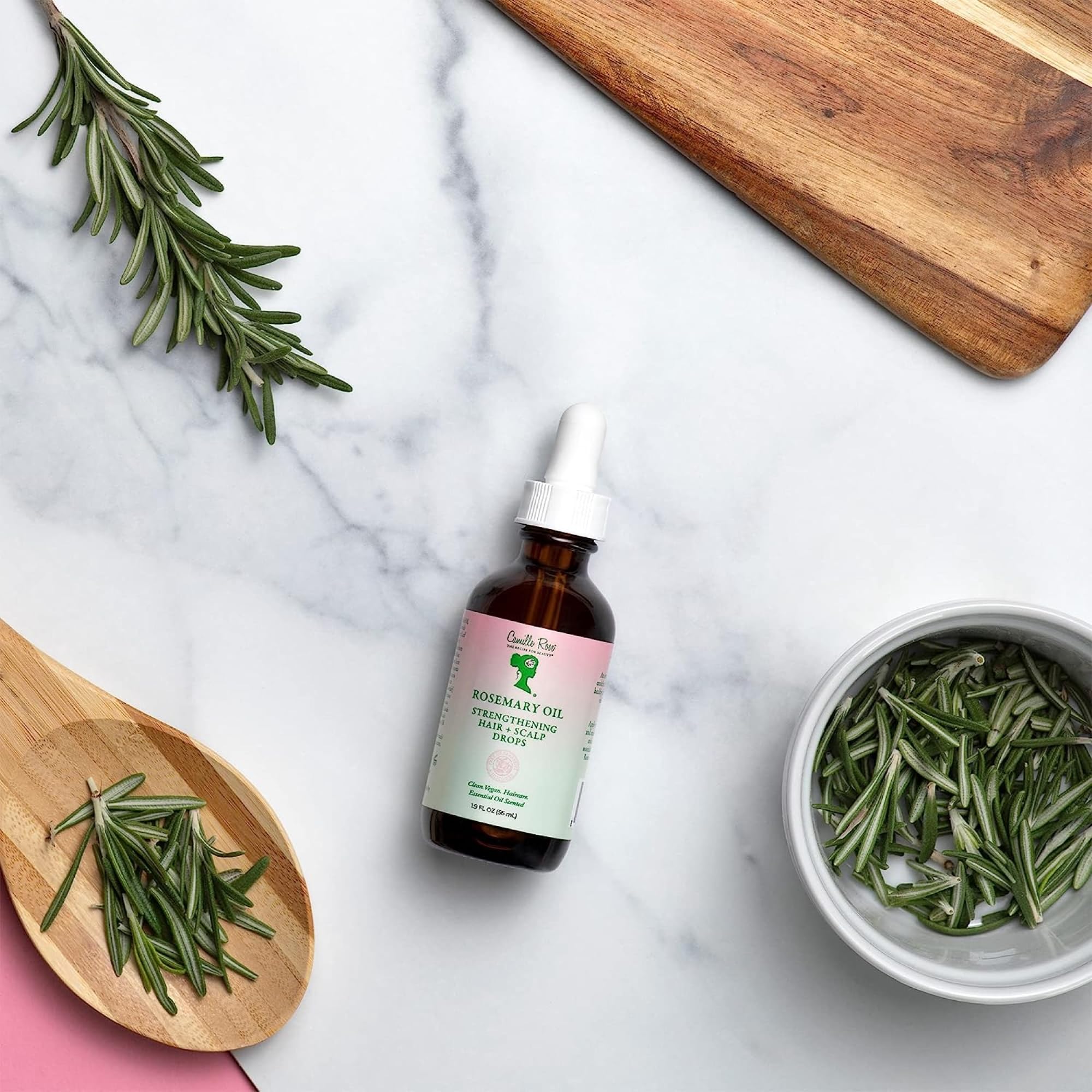 Camille Rose applying drops to scalp for soothing and targeted nourishment