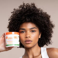 Cantu being applied to dry hair ends demonstrating smoother texture benefit