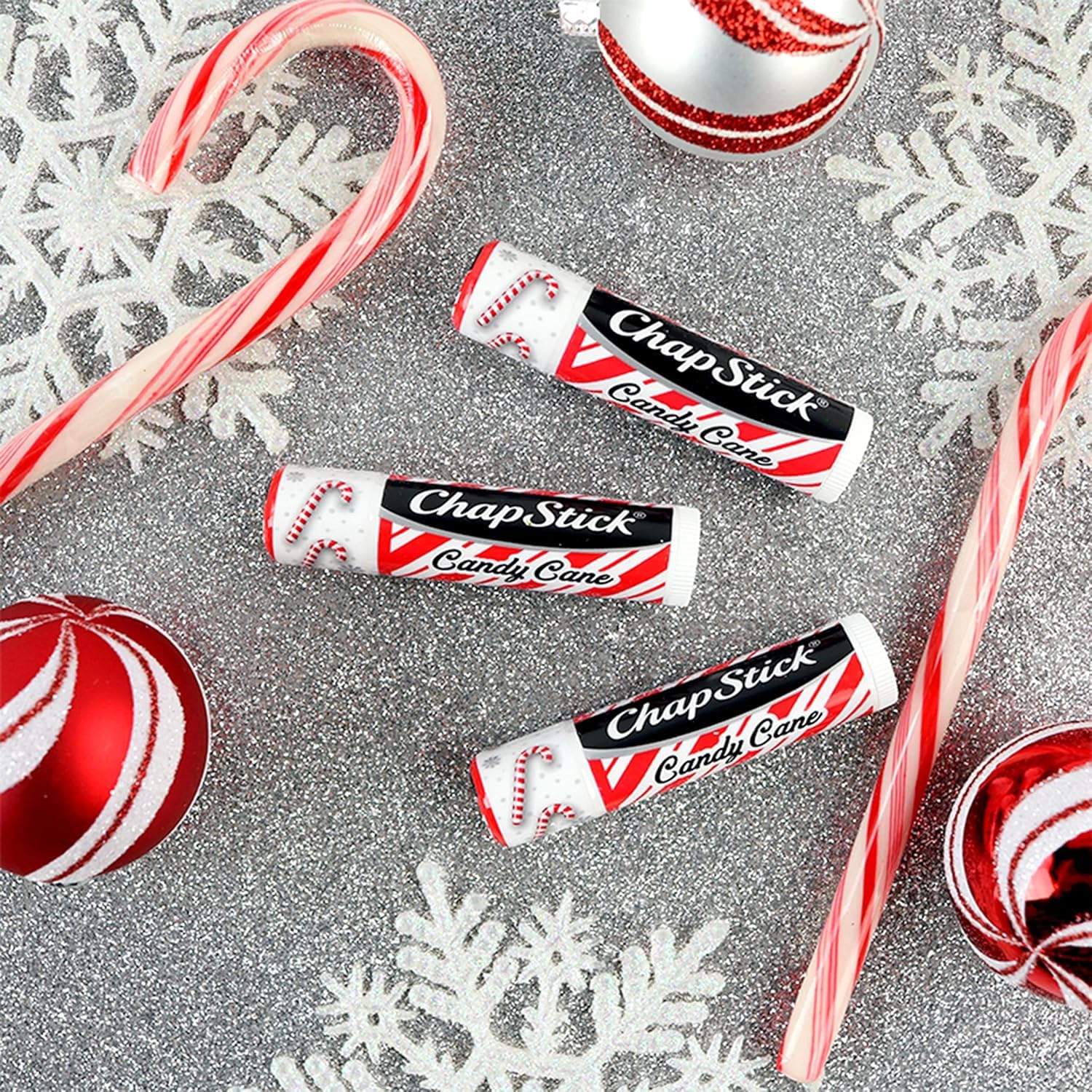 ChapStick Candy Cane next to a coin showing compact travel size