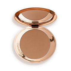 Charlotte Tilbury compact front view shows sleek refillable design and travel benefit