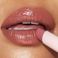 Charlotte Tilbury swatch on arm displaying juicy nude-pink color payoff and shine