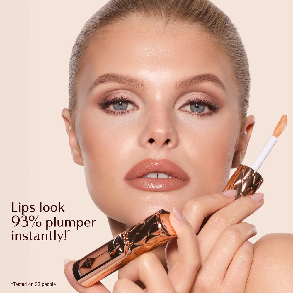 Charlotte Tilbury lip swatch on model showing plumped, glossy nude sparkle benefit