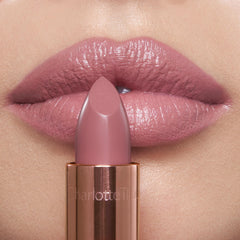Charlotte Tilbury lipstick applied on lips showing cool-toned pink benefit: luminous, fuller-looking pout