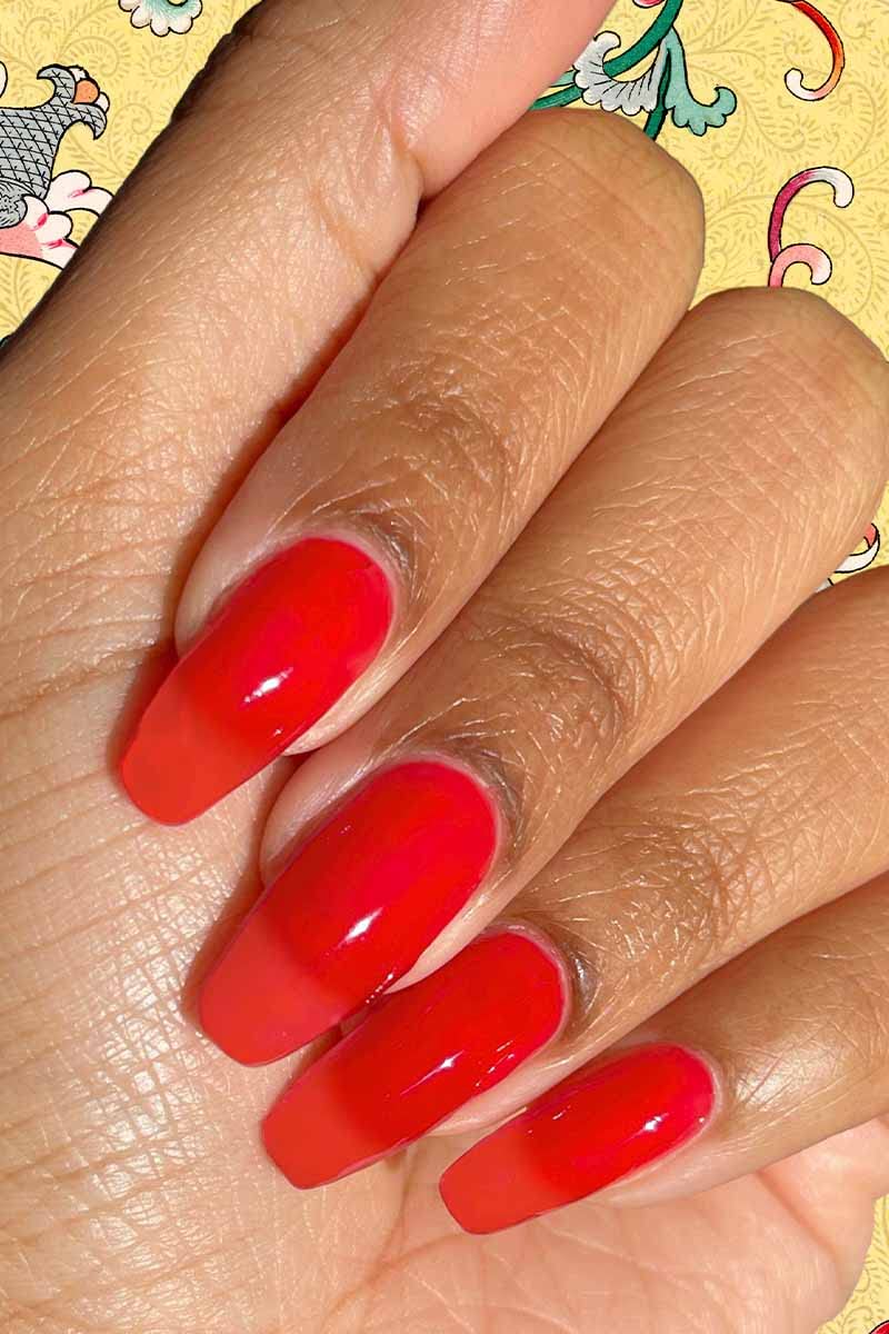 Hand model wearing Lucky Jelly swatch showing buildable sheer red depth
