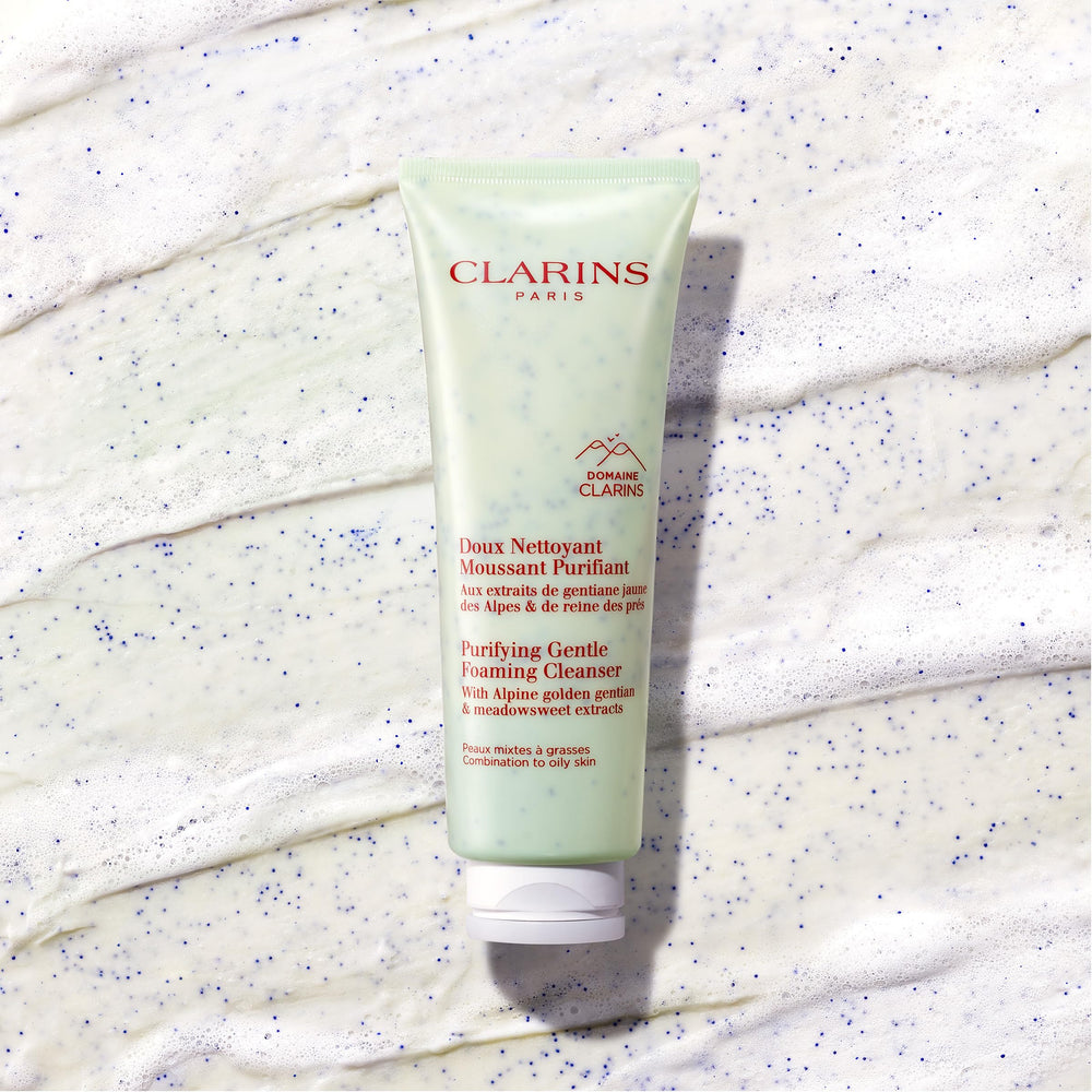 CLARINS tube beside a hand for scale, showing travel-friendly size benefit