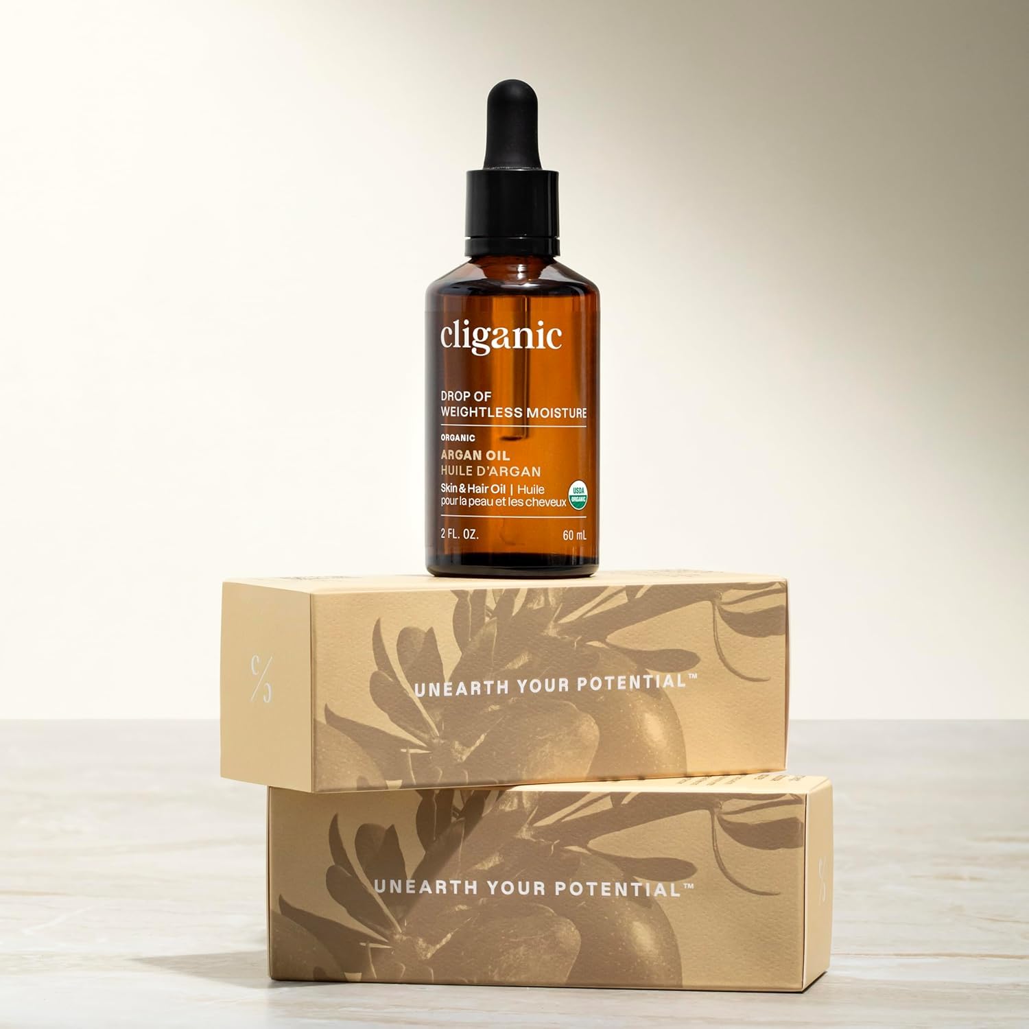 Cliganic argan oil 16oz bottle beside salon tools showing professional value