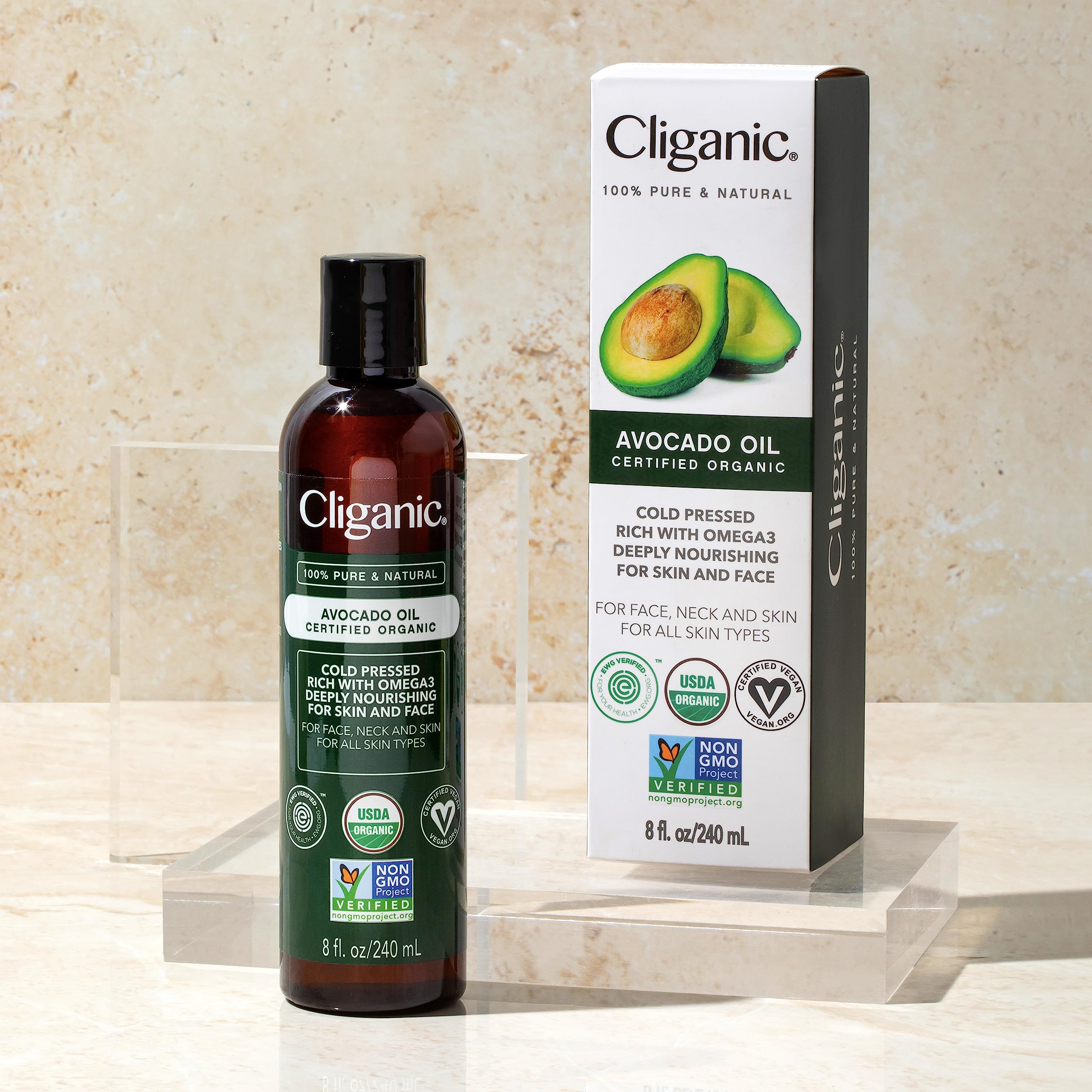 Cliganic bottle beside avocado showing size and natural ingredient sourcing