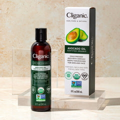 Cliganic bottle beside avocado showing size and natural ingredient sourcing