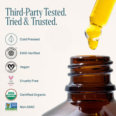 Person applying Cliganic rosehip oil to hair ends for frizz control and shine