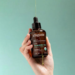 Cliganic tamanu oil held in hand for size comparison showing bottle scale and portability