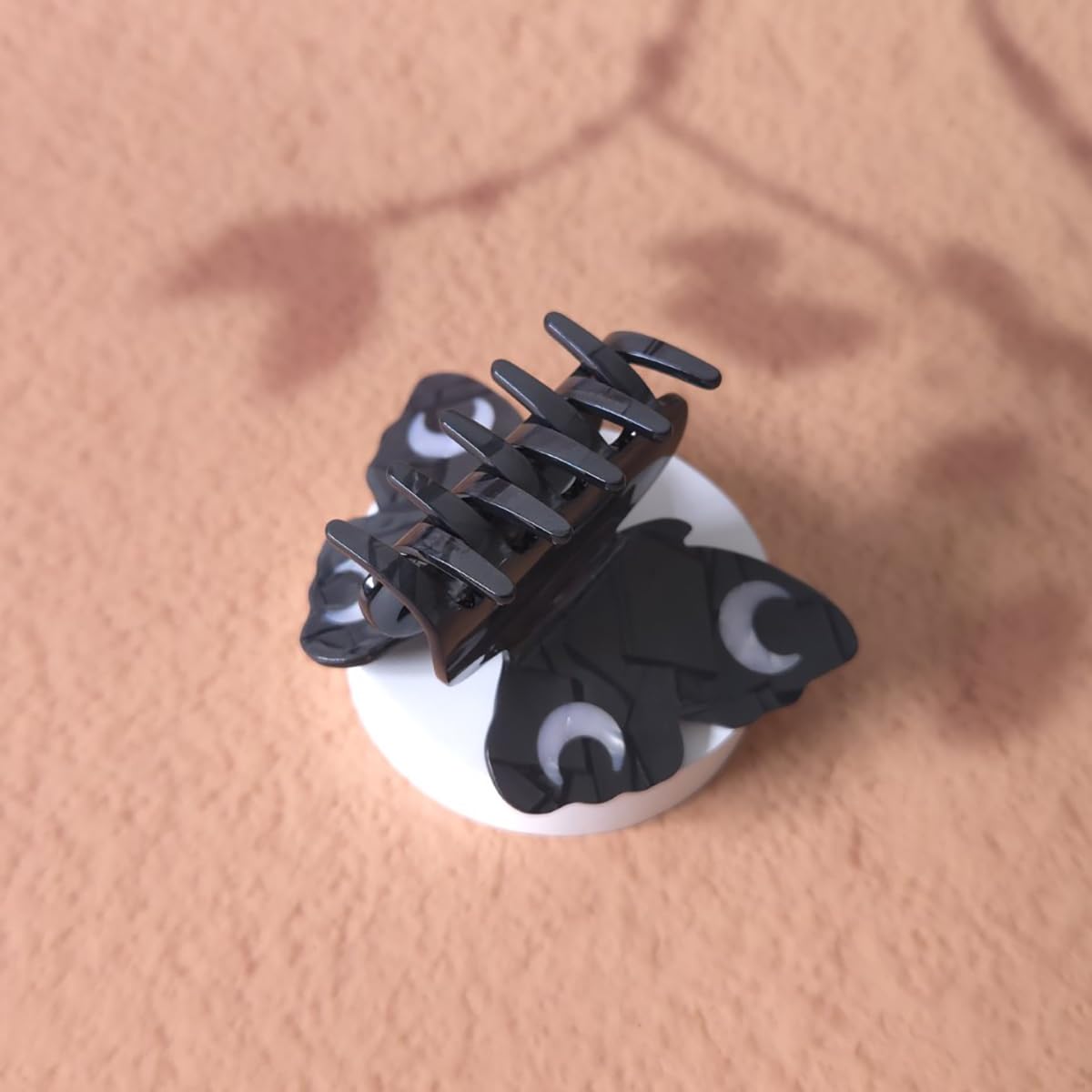 Clip Sugar butterfly clip next to a hand for scale demonstrating compact portability