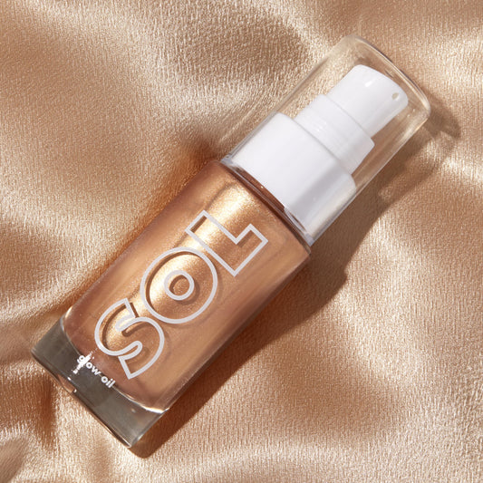 ColourPop mini glow oil applied to shoulder highlighting skin texture and hydrated radiant finish
