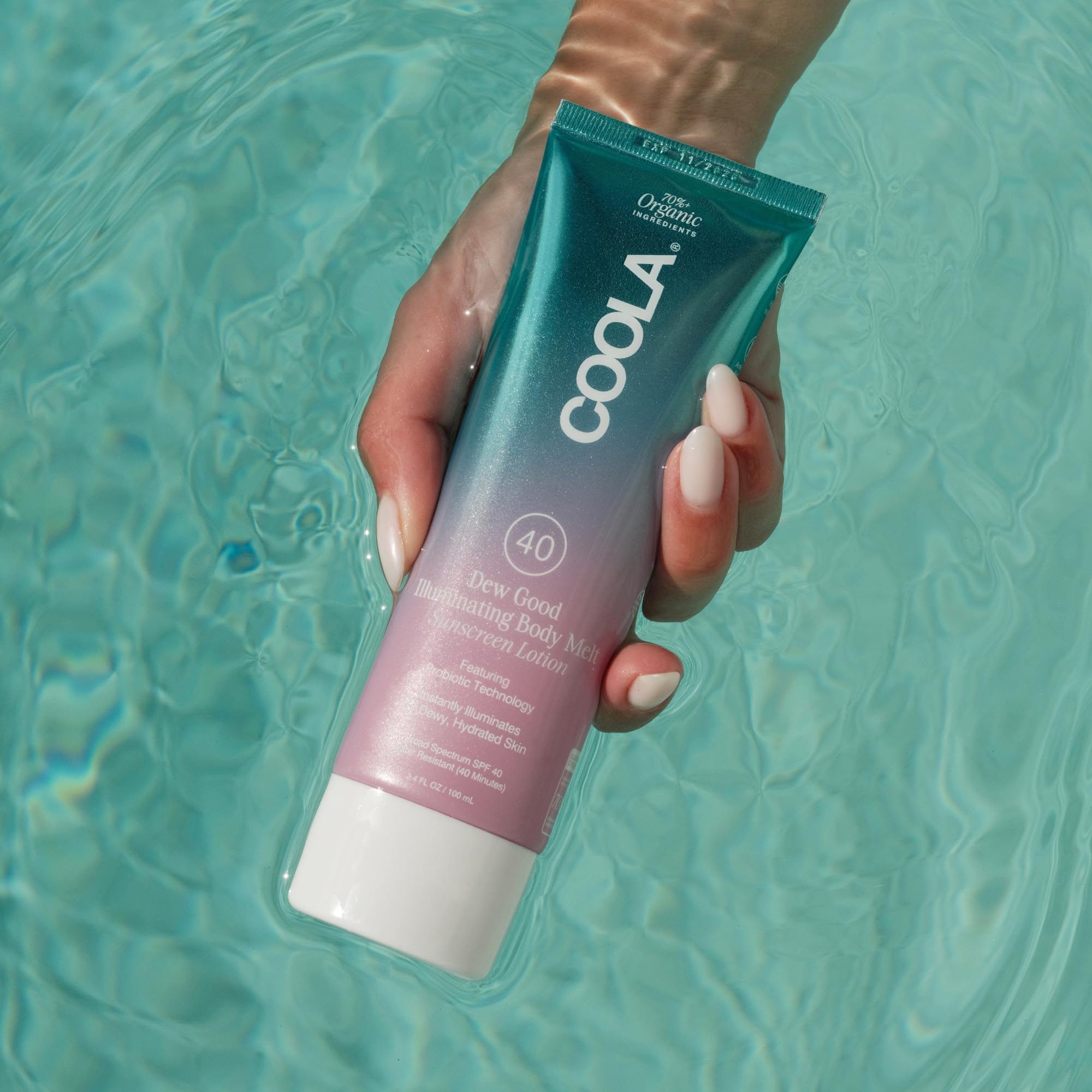 COOLA bottle held in hand for scale showing convenient 3.4 fl oz size