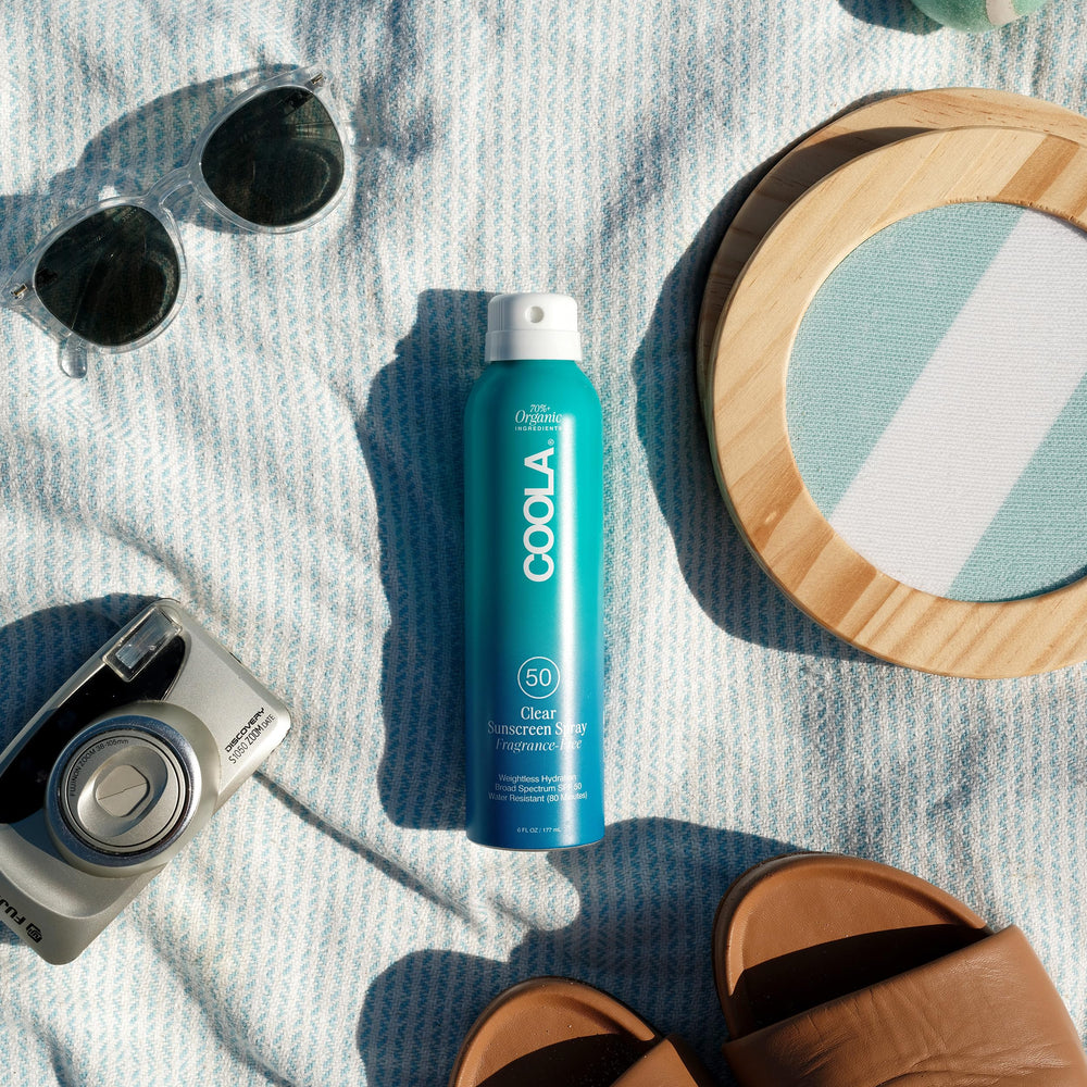 COOLA sunscreen spray being applied from bottle demonstrating easy reapplication