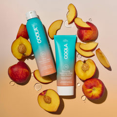 COOLA being sprayed on shoulder for water resistant outdoor activity benefit