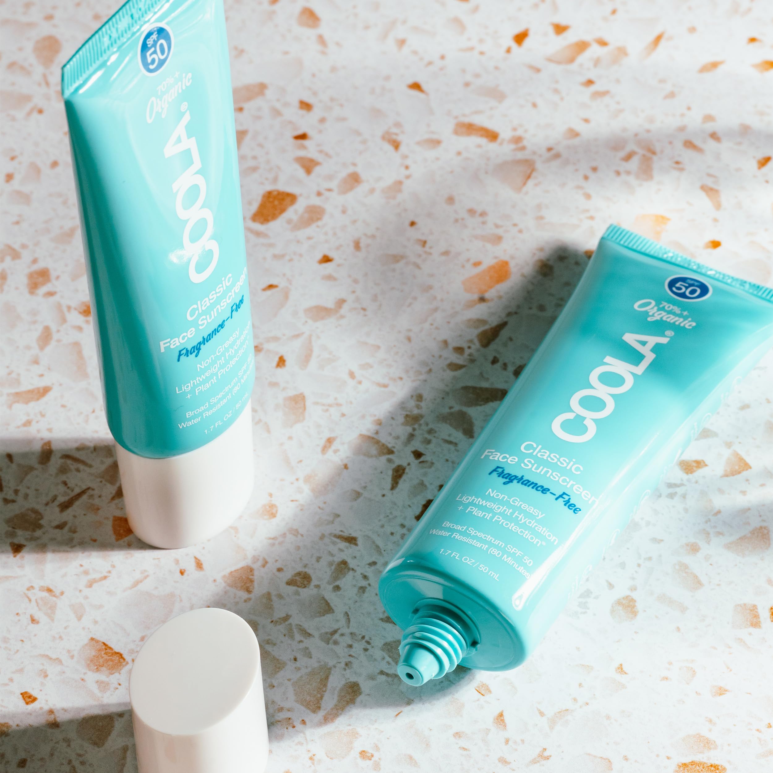 COOLA sunscreen on hand with water droplets showing 80-minute water resistance