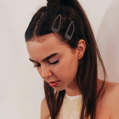 Cptots clip holding bangs in place on model demonstrating secure no-slip styling benefit