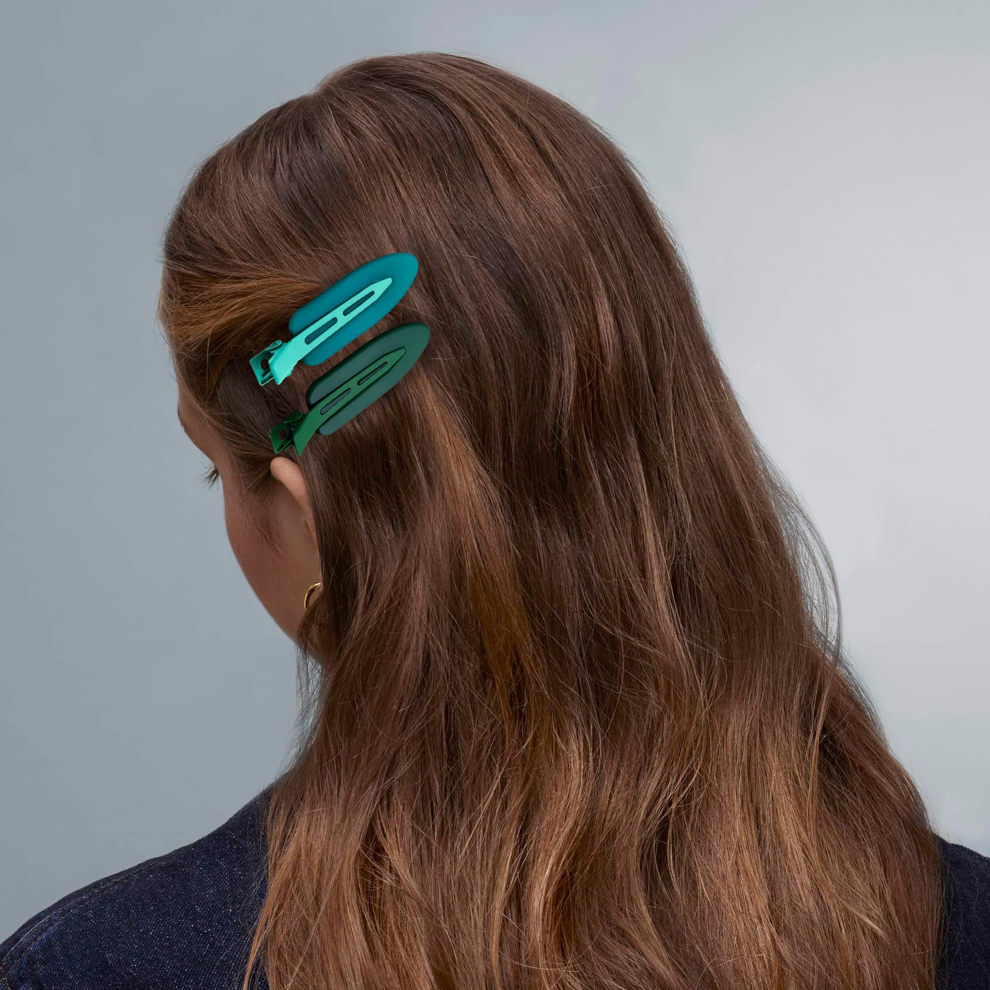 Cptots clip next to a hand for scale demonstrating compact convenience