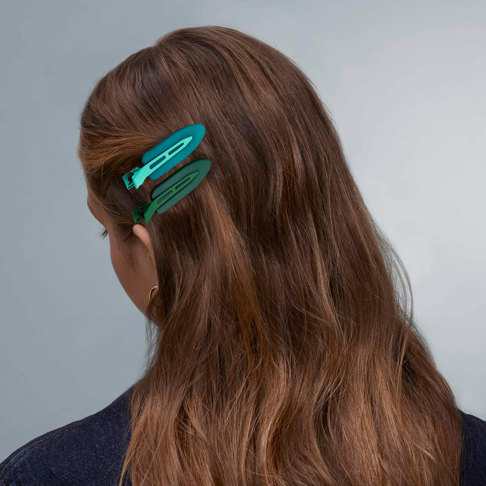 Cptots clip next to a hand for scale demonstrating compact convenience
