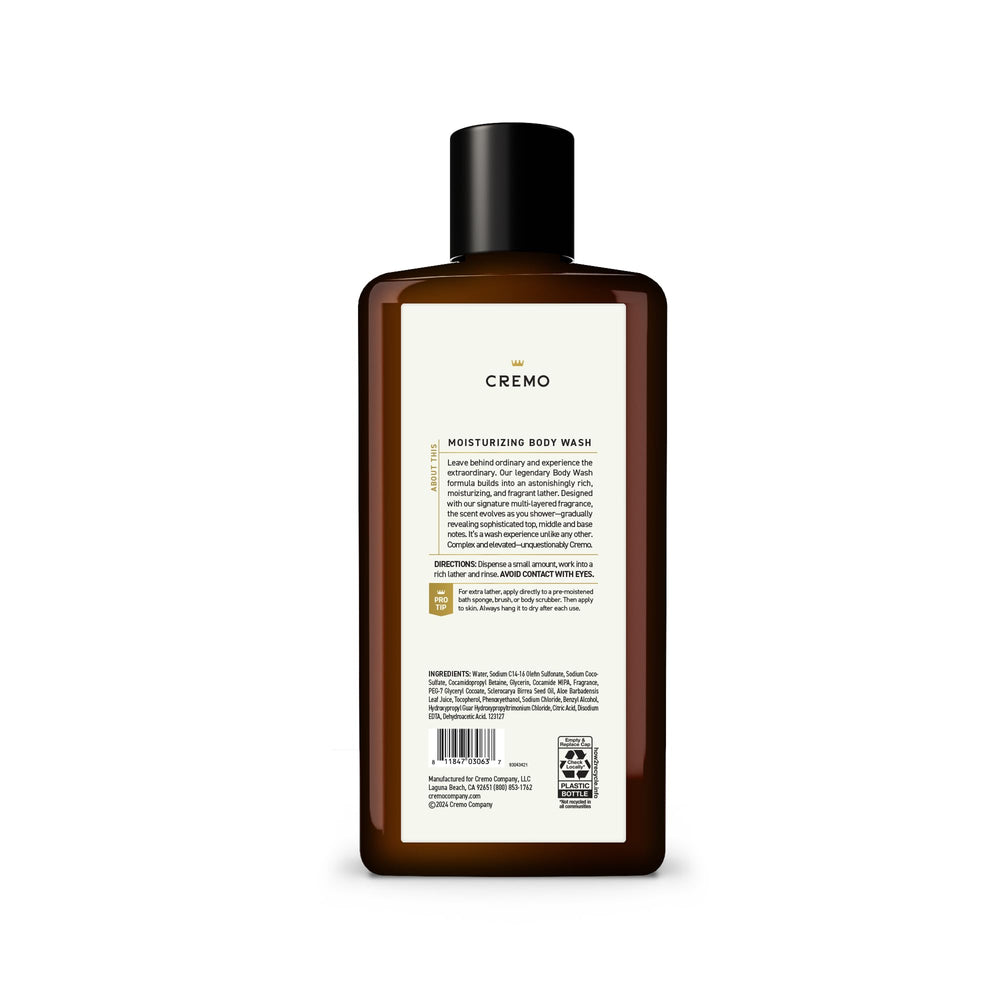 Cremo 16 fl oz bottle beside a water glass for scale showing travel-friendly grooming size