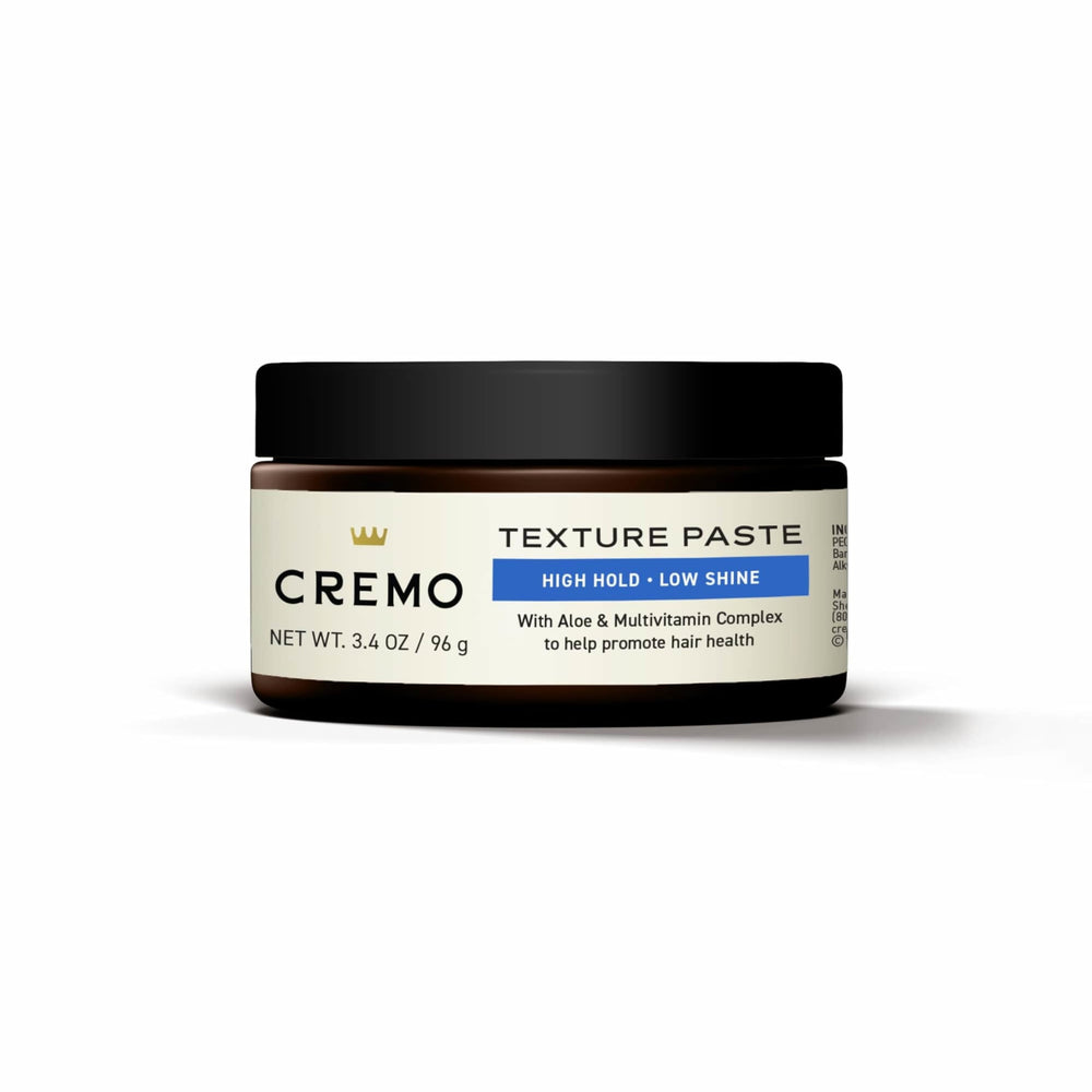 Cremo jar held in hand for scale, emphasizes travel-friendly size