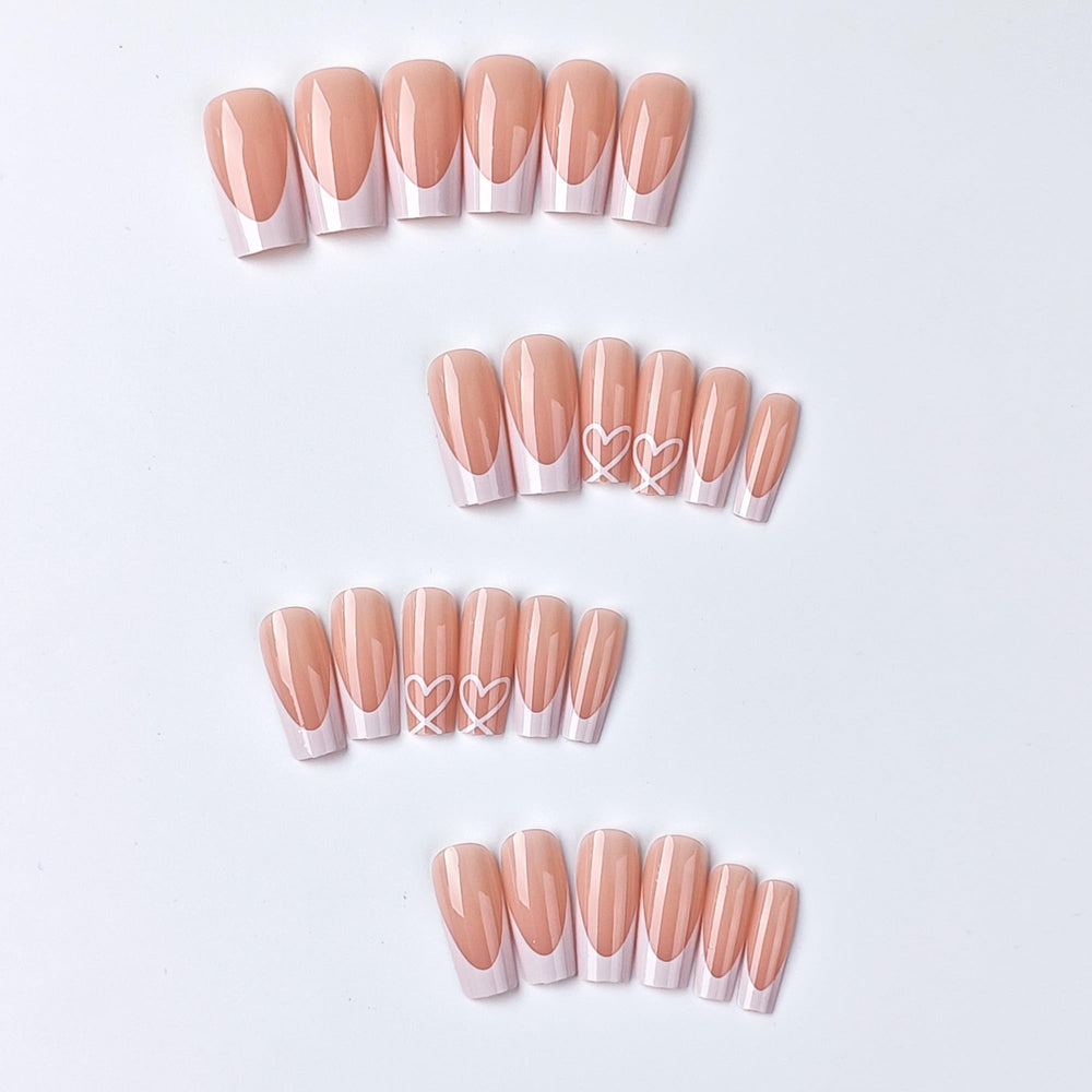 CTTHNBD close-up of heart design on white French tip highlighting stylish detail