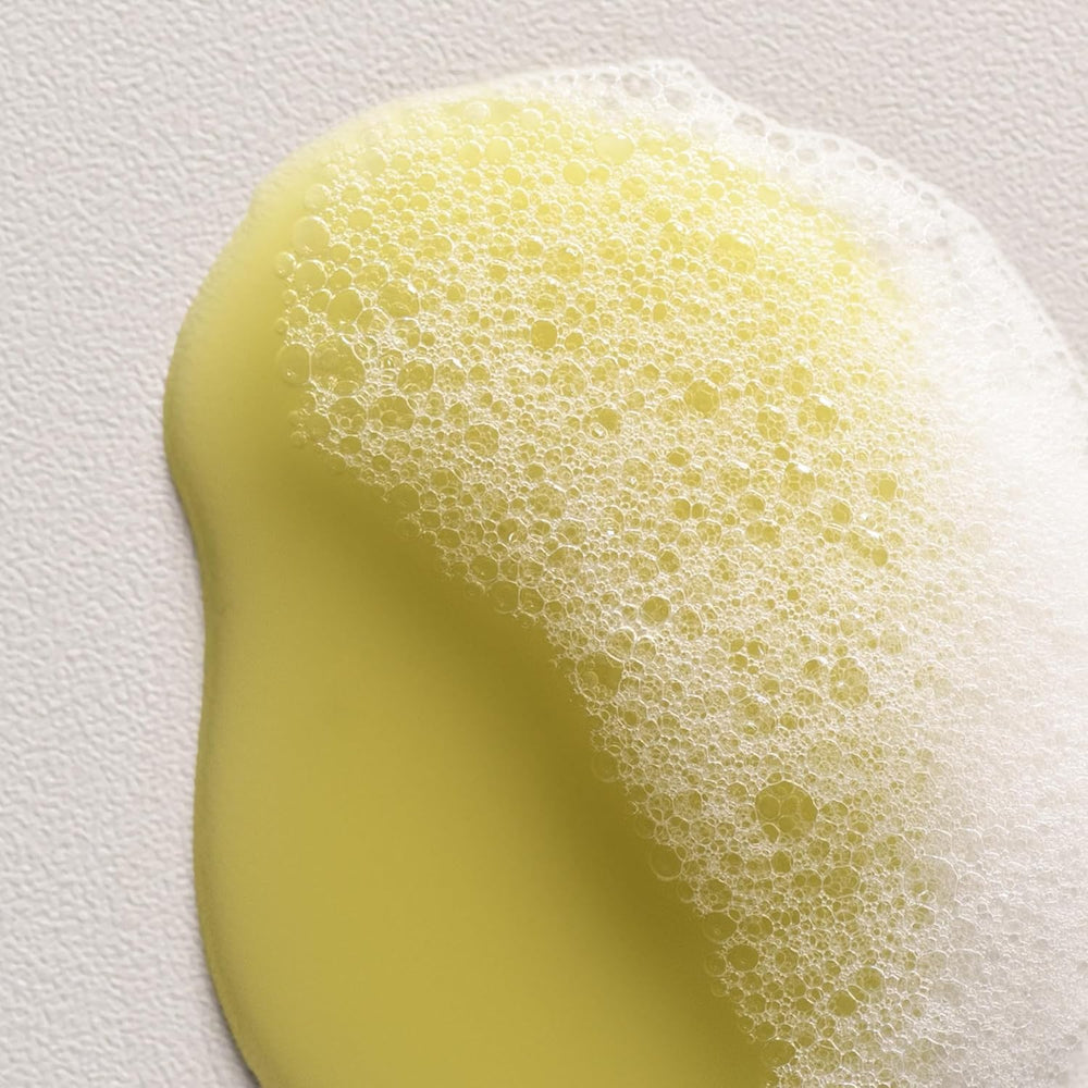 Davines bottle in hand showing 8.45 fl oz scale and travel-friendly benefit