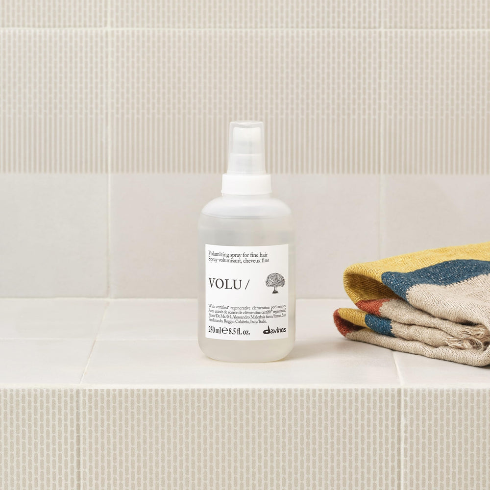 Davines bottle held in hand to show 8.5 fl oz scale and convenience