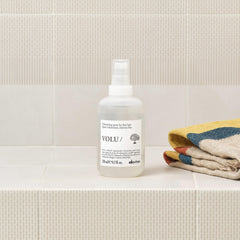 Davines bottle held in hand to show 8.5 fl oz scale and convenience