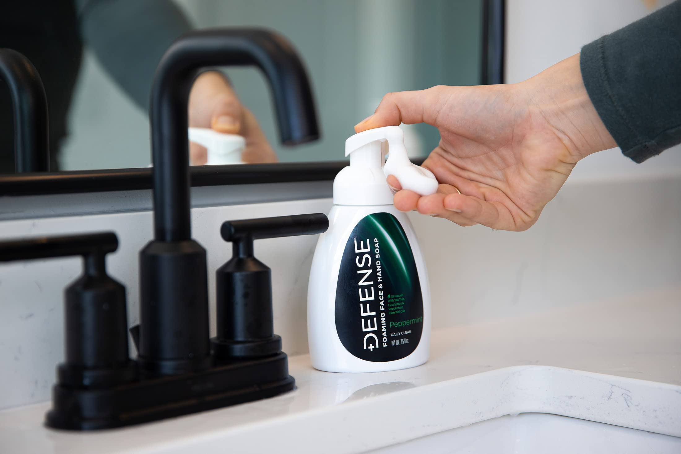 Defense Soap bottle beside phone showing compact 7.5 fl oz travel size